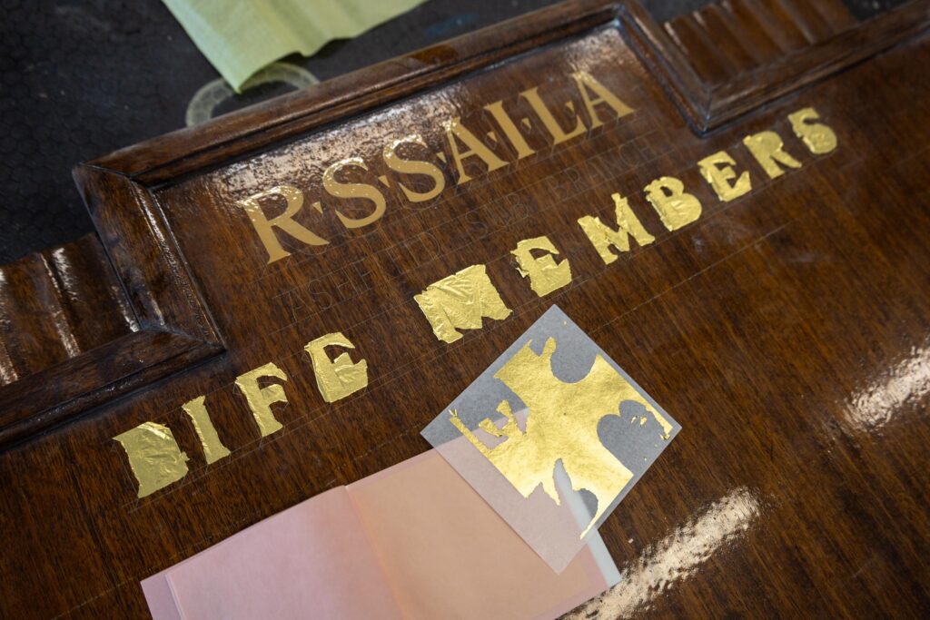 gold leaf being applied to a honour board